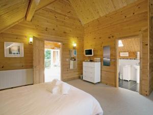a bedroom with a white bed in a wooden room at Hillview in Little Petherick