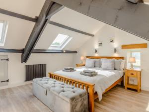 a bedroom with a large bed and a couch at Kerseycleugh Bridge Cottage in Kielder