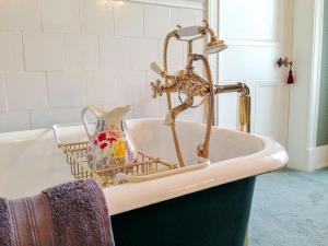 a bathroom with a bath tub with a faucet at Dunvarlich House in Aberfeldy