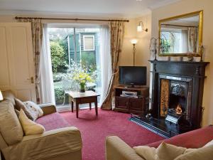 a living room with a fireplace and a television at Lace Cottage in Ashbourne