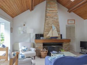 a living room with a fireplace with a sailboat on it at Topsail in Newton Ferrers