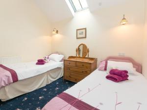 two twin beds in a room with a dresser at Bickley School Annexe in Broxa