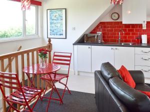 a kitchen and a living room with a table and a couch at Hillcroft in Cold Norton