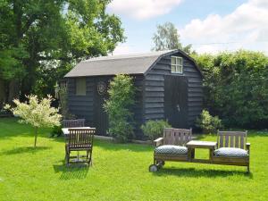 twee stoelen en een tafel voor een cabine bij Hillcroft in Cold Norton