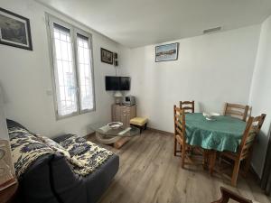 een woonkamer met een bank en een tafel bij Maison Port-Vendres, 3 pièces, 4 personnes - FR-1-309-203 in Port-Vendres