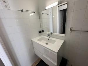 een witte badkamer met een wastafel en een spiegel bij Maison Port-Vendres, 3 pièces, 4 personnes - FR-1-309-203 in Port-Vendres