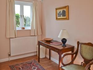 LyminsterにあるStable Cottageのデスク、椅子、窓が備わる客室です。