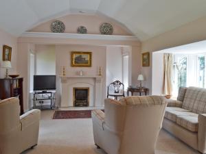 a living room with two couches and a fireplace at Stable Cottage in Lyminster