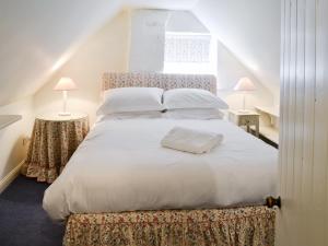 ein Schlafzimmer mit einem großen weißen Bett mit zwei Lampen in der Unterkunft Swiss Cottage in Rievaulx