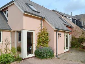 a pink house with a pitched roof at Cherry Tree Cottage in Bovey Tracey