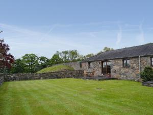 a stone house with a large yard in front of it at Beudy Bach - 16986 in Brynsiencyn