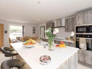 een keuken met een tafel met een vaas met bloemen bij Barn Owl Cottage in Skidby