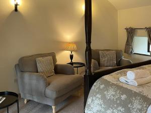 a bedroom with a bed and a chair and a lamp at The Chapel in Kilnsey