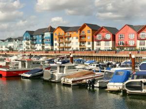 um grupo de barcos ancorados numa marina com edifícios em Folly Cottage em Kentisbeare