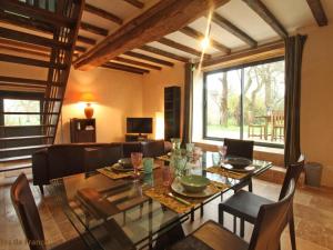 a dining room with a table and chairs and a couch at Charmante maison spacieuse avec terrasse et jardin, chiens acceptés, proche d'Alençon, WIFI - FR-1-497-163 in Colombiers