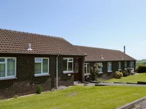 a row of houses with grass in front of them at Eider Cottage in Embleton