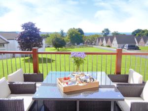 a table with a vase of flowers and a box on a balcony at Tamar Ten in Gunnislake