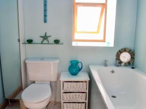 a bathroom with a toilet and a sink and a tub at Sea Yonder in Buckie