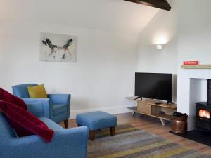 a living room with two chairs and a television at Bellhouse Croft in Shelley