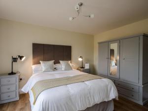 um quarto com uma grande cama branca e um armário em Bentleys Barn em Wingerworth
