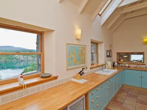 a kitchen with a counter and a large window at Rubha Lodge in Shieldaig