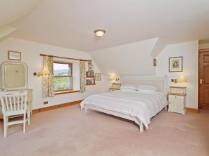 1 dormitorio con cama blanca y ventana en Rubha Lodge, en Shieldaig