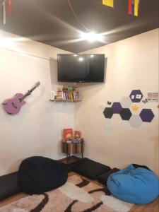 a room with a tv and a bean bag chair at Sleepbox Hotel in Cameron Highlands