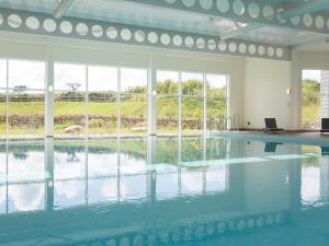 a swimming pool with water in a room with windows at Una Argentum 60 in Carbis Bay