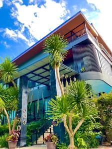 a building with palm trees in front of it at Sea Smile Green View Pool Villa KRABI Klong Muang in Klong Muang Beach