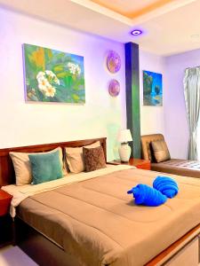 a bedroom with a bed with a blue pillow on it at Sea Smile Green View Pool Villa KRABI Klong Muang in Klong Muang Beach