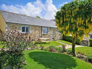 a stone house with a garden in front of it at Maple Barn in Porthtowan