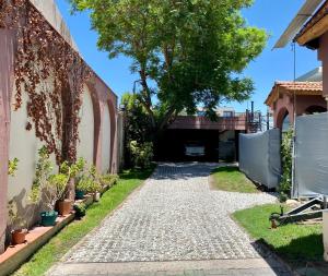 a walkway leading to a house with a tree at Departamento Excelente Ubicación. Zona Arístides y Parque. in Mendoza