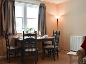 a dining room table with chairs and a window at Elm Court 7 in Keswick