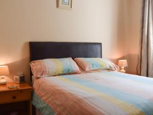 sypialnia z łóżkiem z czarnym zagłówkiem i 2 poduszkami w obiekcie Elm Court 7 w mieście Keswick