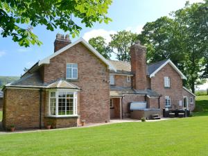 an old brick house with a lawn at Cefnaire in Newtown