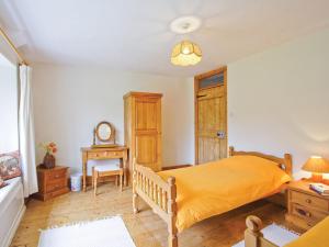 um quarto com uma cama, uma mesa e uma cadeira em Manor House em Uny Lelant