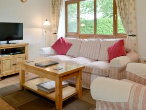 a living room with a couch and a table at Orchard Cottage-23895 in Aylmerton