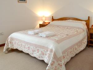 a bedroom with a bed with two towels on it at Orchard Cottage-23895 in Aylmerton