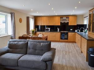 a living room with a couch and a kitchen at Booth Farm Cottage in Buxton