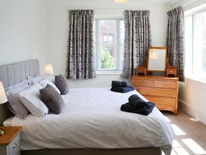 una camera da letto con un letto con specchio e un comò di Three The Boulevard a Sheringham