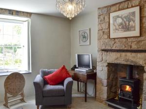 a living room with a chair and a fireplace at The Mill Farmhouse in Llandybie