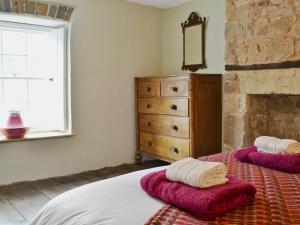 a bedroom with a bed with towels on it at The Mill Farmhouse in Llandybie