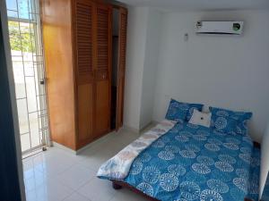 1 dormitorio con 1 cama con edredón azul en Cómodo apartamento en el rodadero en Rodadero