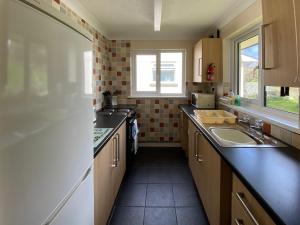 eine kleine Küche mit einem Waschbecken und einem Fenster in der Unterkunft Tresco - B6520 in Saint Cleer
