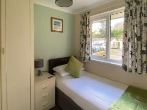 a small bedroom with a bed and a window at Tresco - B6520 in Saint Cleer