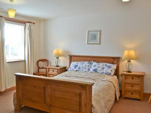 a bedroom with a large bed and two night stands at Alices Cottage in Lanehead