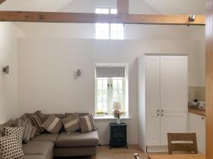 uma sala de estar com um sofá e uma janela em Princess Cottage em Martin