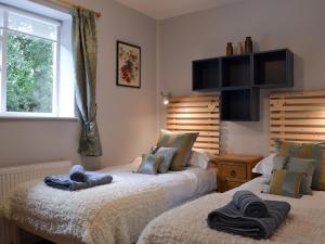 twee bedden naast elkaar in een slaapkamer bij Burrills View in Horderley