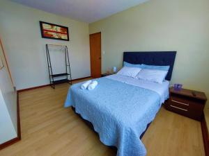 a bedroom with a bed with a blue comforter at Casa Mahulu in Paracas
