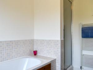 a bathroom with a bath tub and a shower at Shingle Cottage in Whitstable